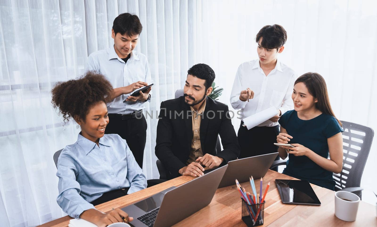 Happy diverse business people work together, discussing in corporate office. Professional and diversity teamwork discuss business plan on desk with laptop. Modern multicultural office worker. Concord