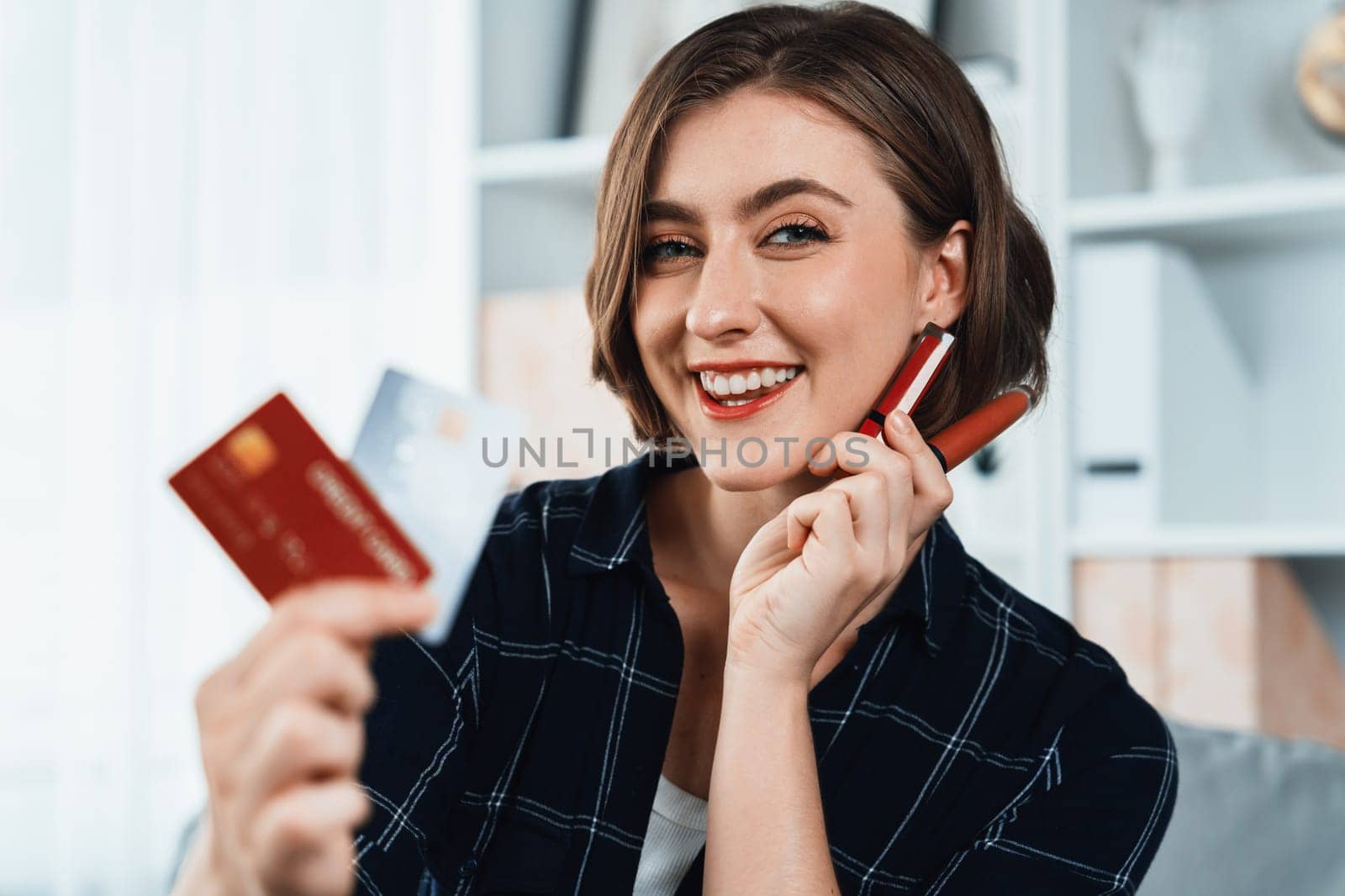 Young happy woman buy product by online shopping at home while ordering items from the internet with credit card online payment system protected by utmost cyber security from online store platform