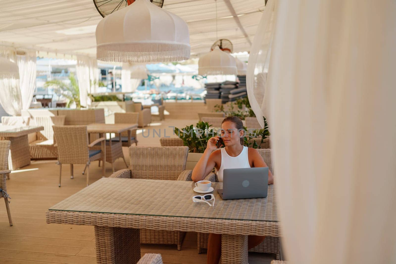 Woman coffee cafe macbook. Woman sitting at a coffee shop with mobile phone drinking coffee and looking away. Caucasian female relaxing at a cafe.