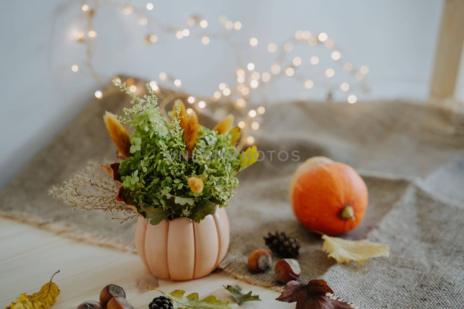 Autumn composition. Pumpkin. Thanksgiving Day. Garland with warm light. Bokeh. by Rodnova