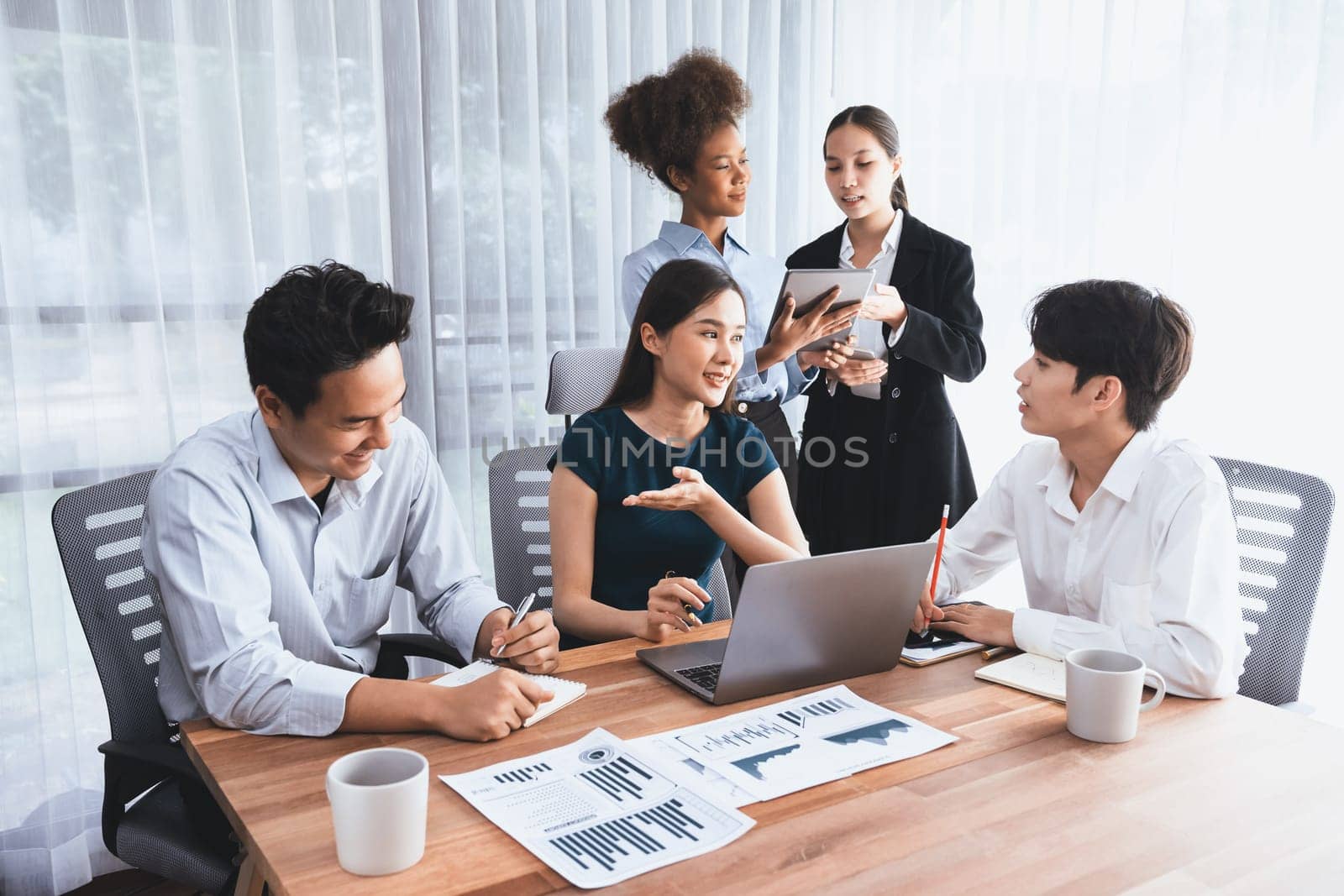 Multiracial analyst team use BI dashboard data to analyze financial report on meeting table. Group of diverse business people utilize data analysis by FIntech for success business marketing. Concord