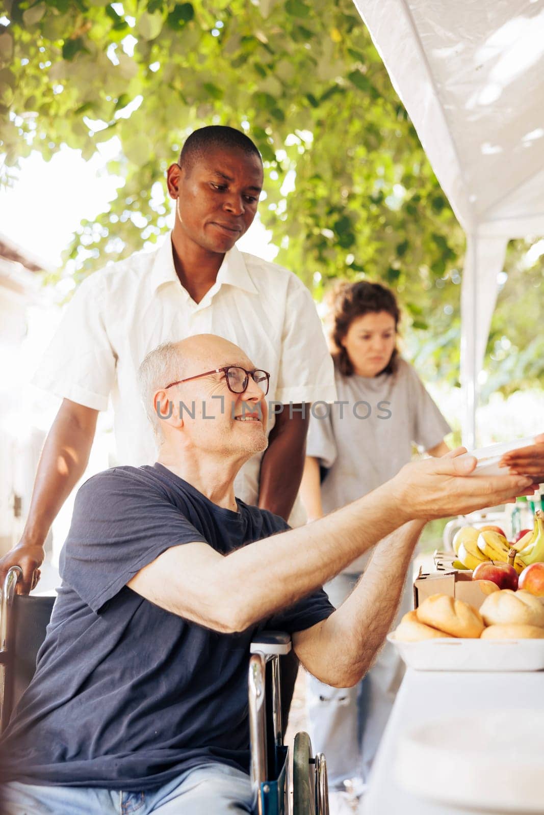 Charitable team provides aid and food to needy and distribute free food including fresh fruits to homeless individuals. Disabled person in a wheelchair also receives hunger relief support.