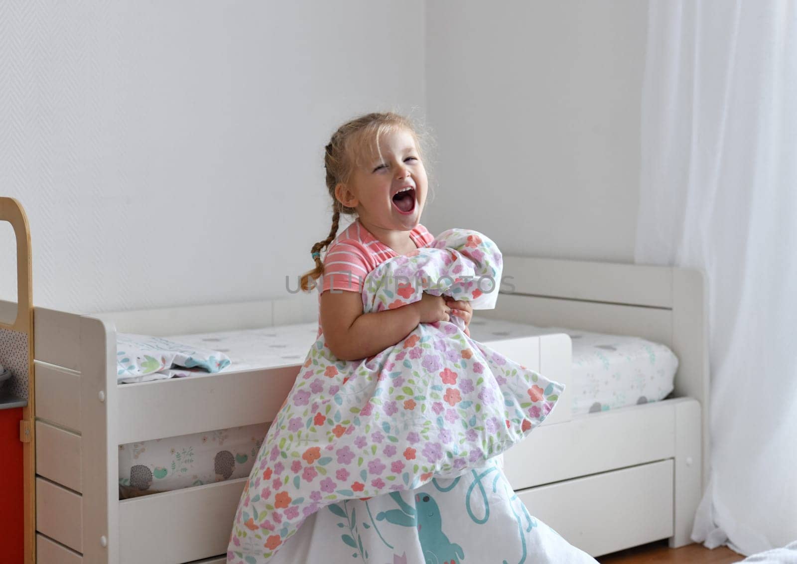 A girl makes a bed in the children room