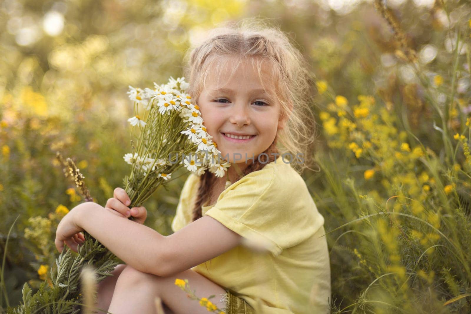 Girl with a bouquet of daisies sits in a forest