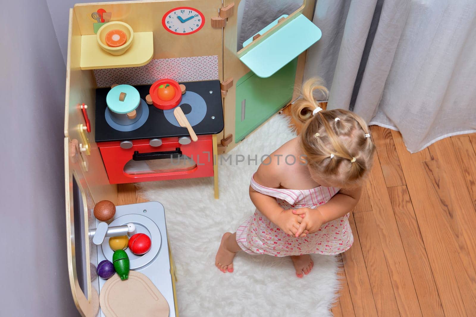 Girl playing with toy on a small kitchen