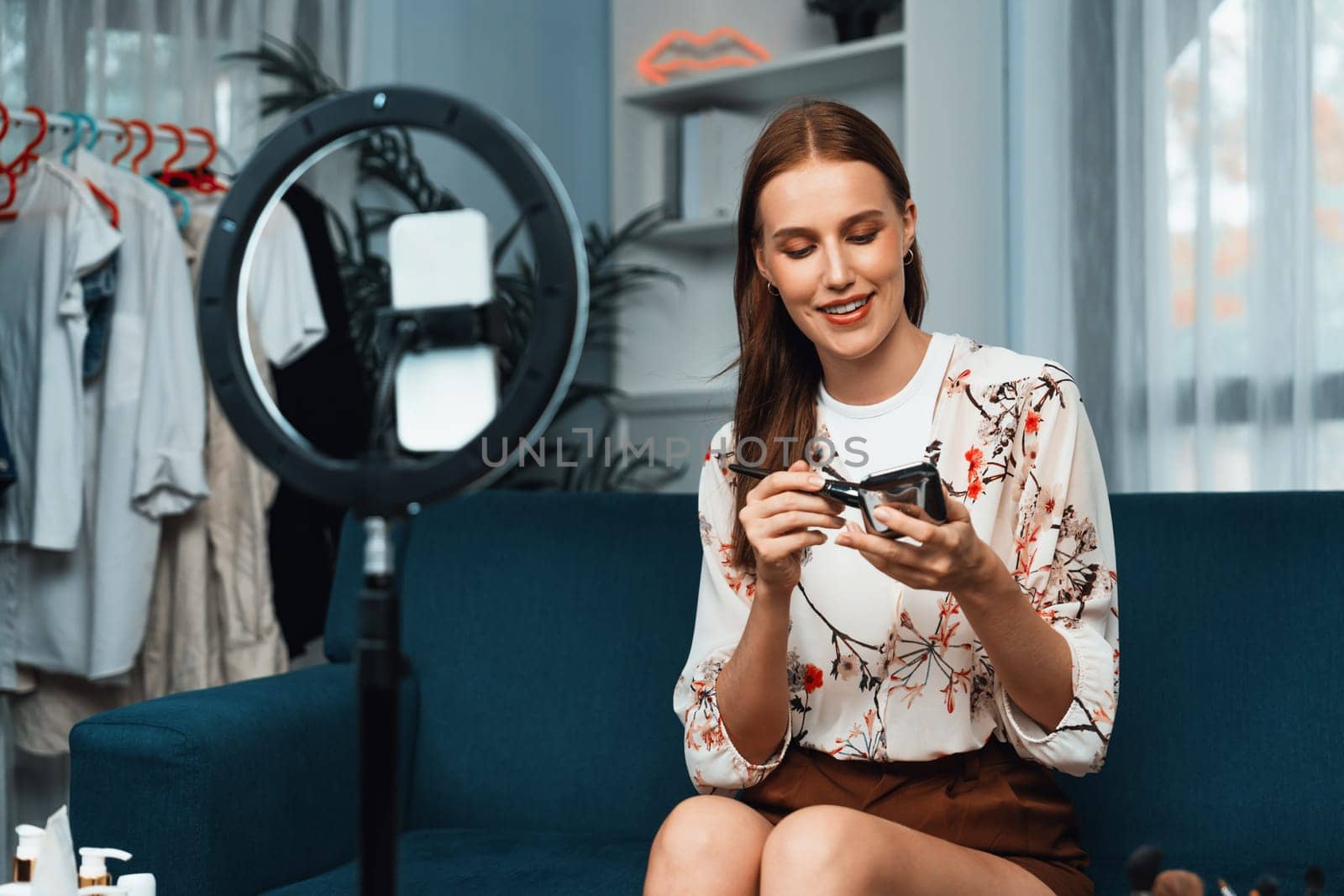 Woman influencer shoot live streaming vlog video review makeup utmost social media or blog. Happy young girl with cosmetics studio lighting for marketing recording session broadcasting online.