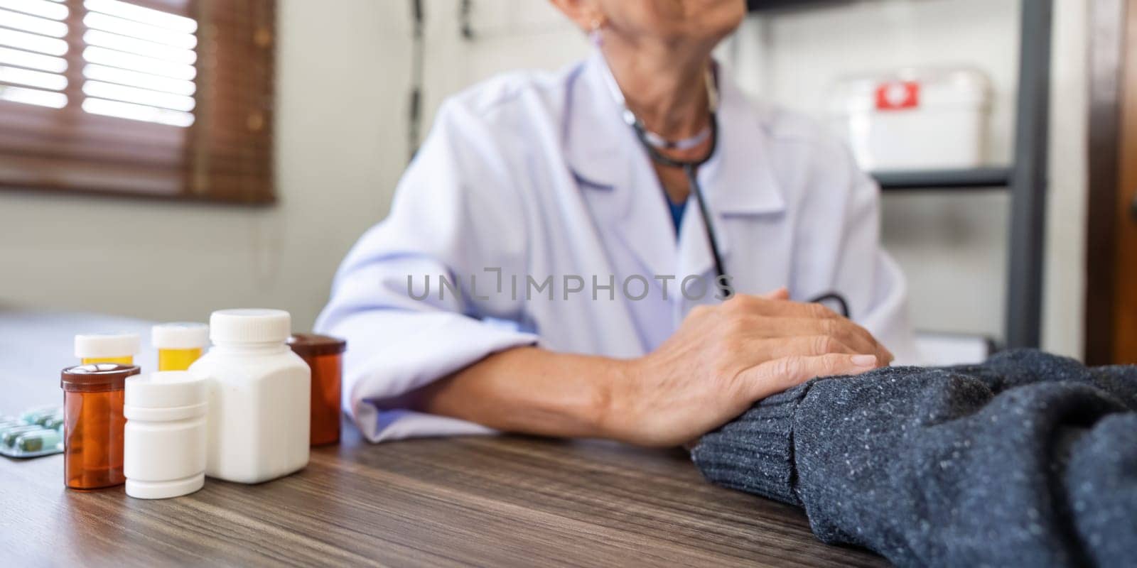 Senior woman doctor wear white medical uniform holding hand of female patient having disease health problem give support help empathy and people healthcare concept.