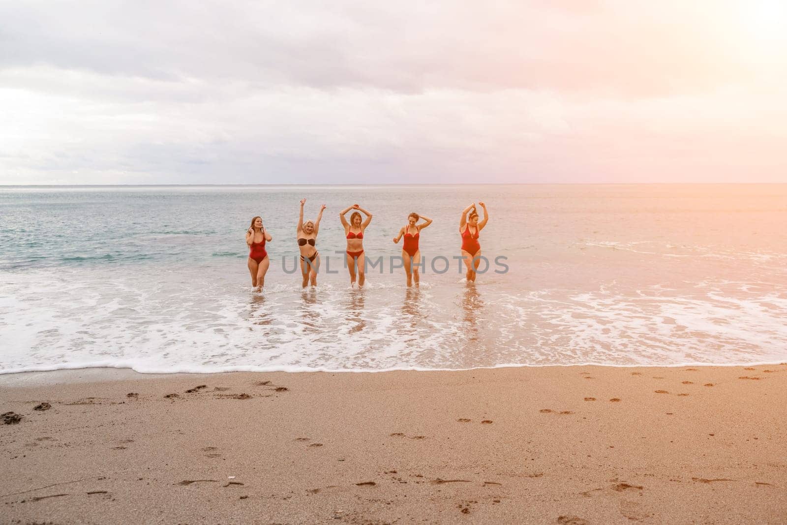 Big happy family or group of five friends is having fun against sunset beach. Beach holidays concept