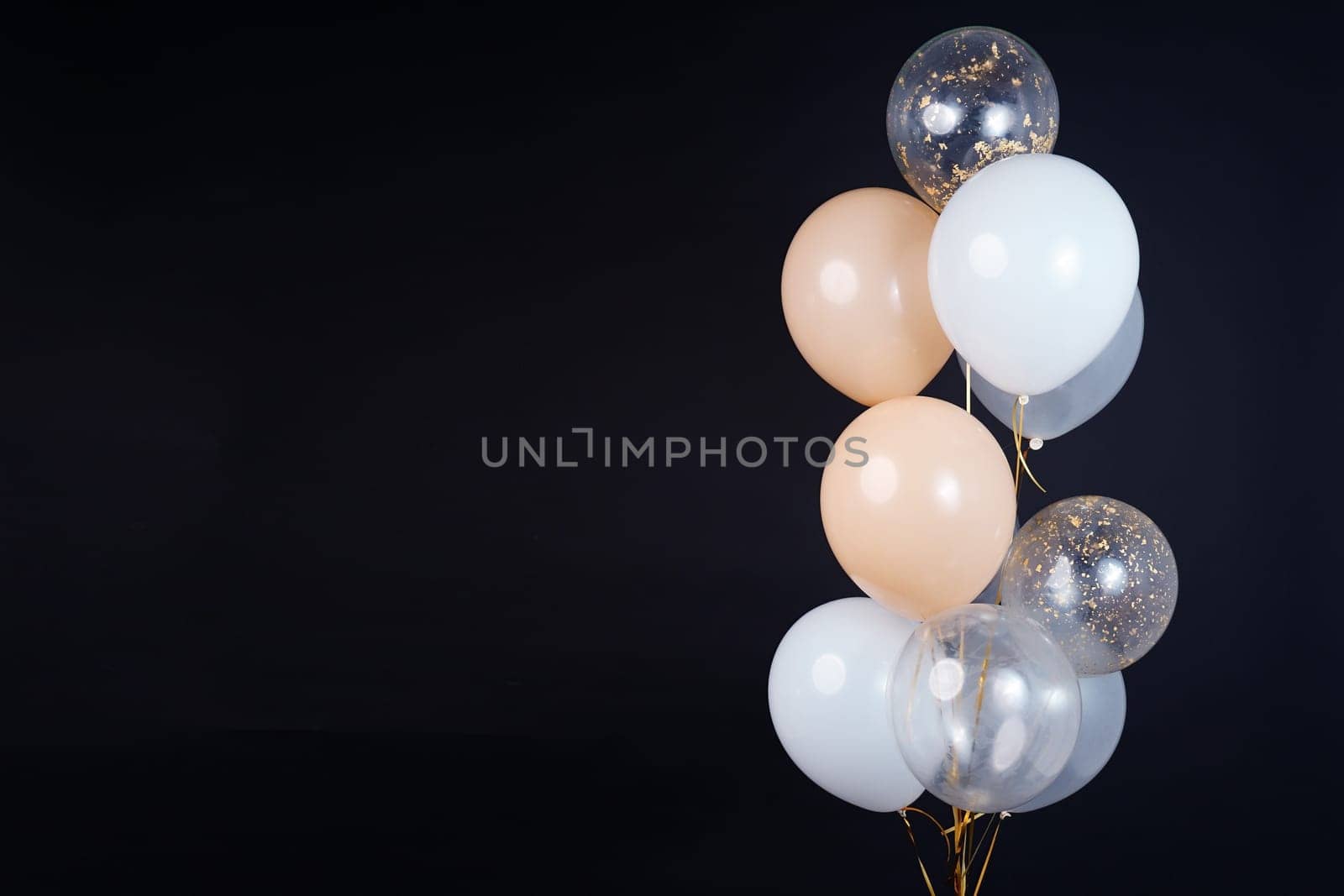 A bunch of balloons in white, beige and transparent colors on a dark background with space for an inscription by tewolf