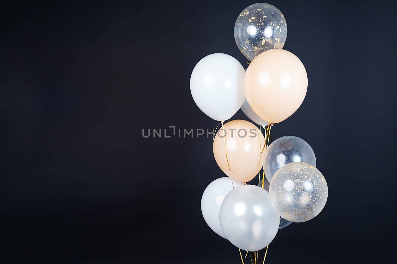 On a black background, balloons of light shades - white, beige, transparent - are flying. Space for text by tewolf