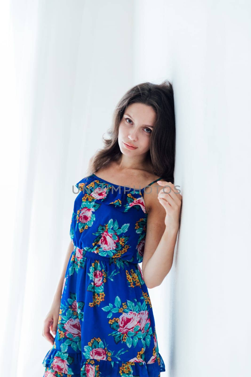 beautiful woman in blue floral dress on a white background