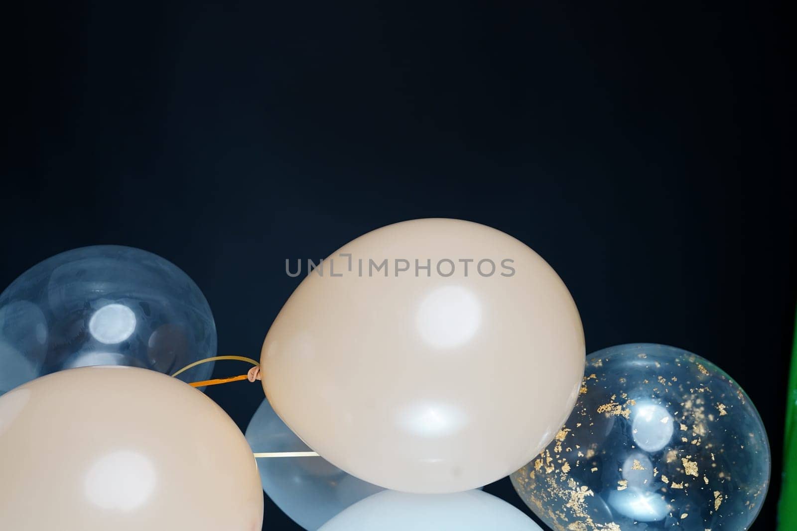 On a black background, balloons of light shades - white, beige, transparent - are flying. Space for text by tewolf