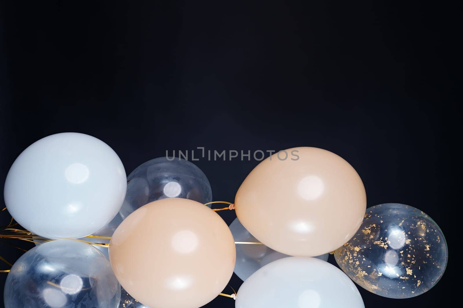 On a black background, balloons of light shades - white, beige, transparent - are flying. Space for text by tewolf