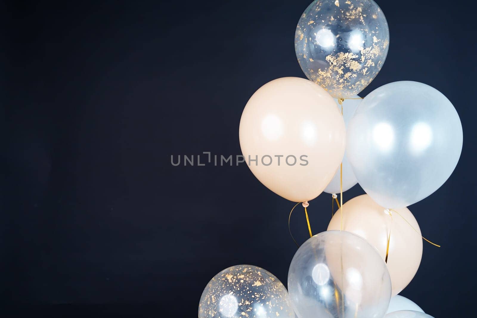 Bunch of balloons of white, beige and transparent colors on a dark background. Place for the inscription by tewolf