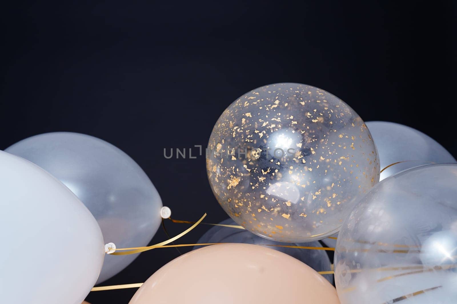 On a black background, balloons of light shades - white, beige, transparent - are flying. Space for text by tewolf