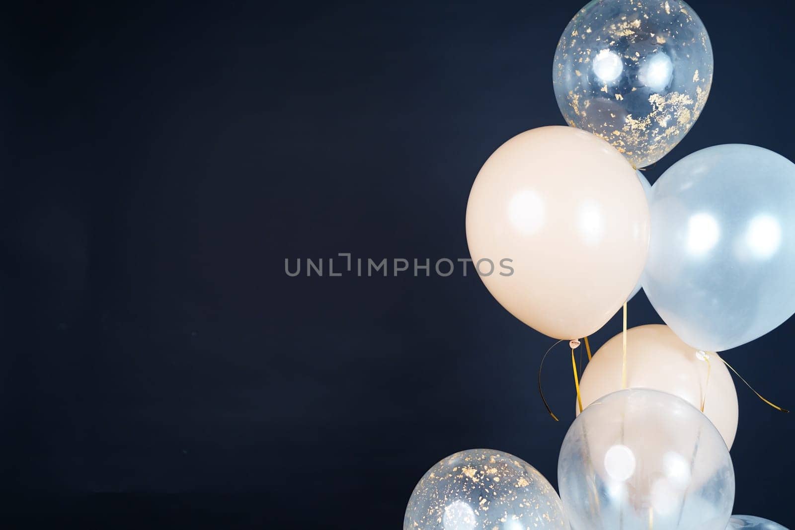 Bunch of balloons of white, beige and transparent colors on a dark background. Place for the inscription by tewolf