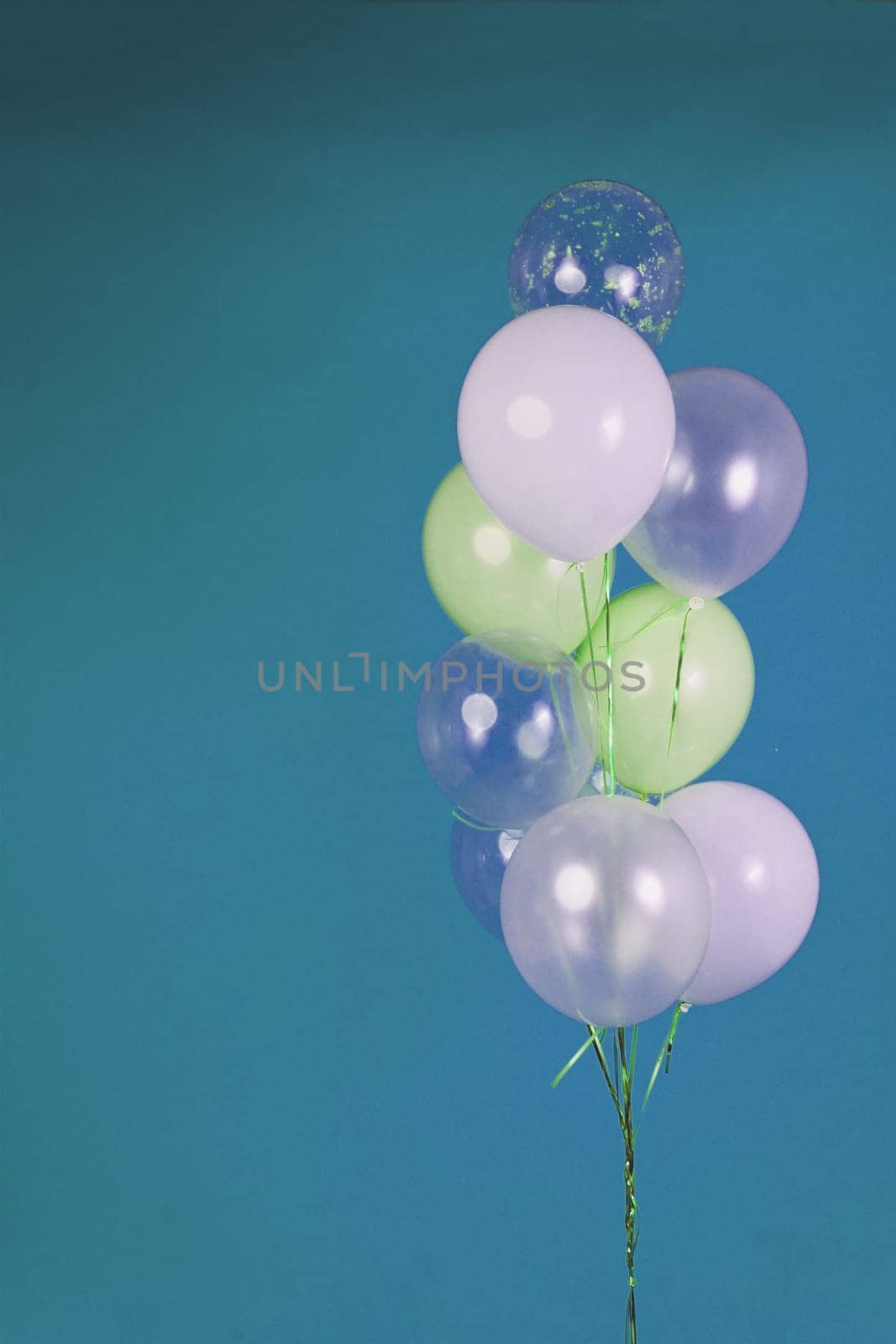 Balloons of light colors - white, light green, transparent on a blue background. High quality photo