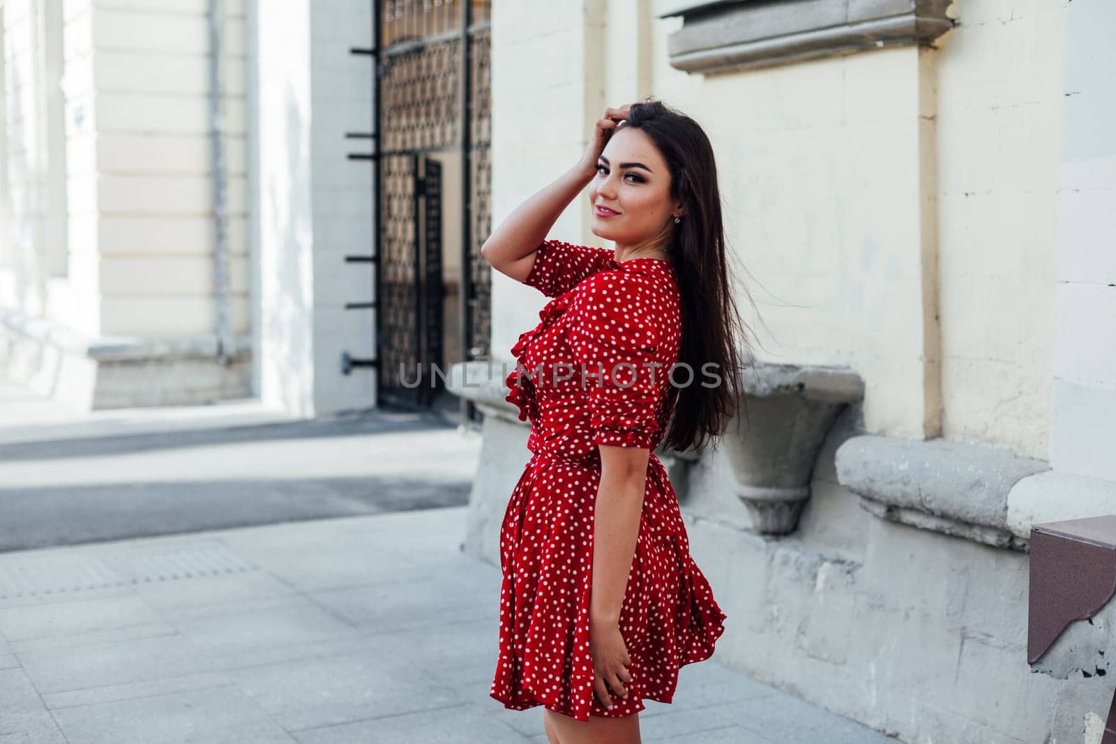 woman in red dress walk outside holiday travel by Simakov