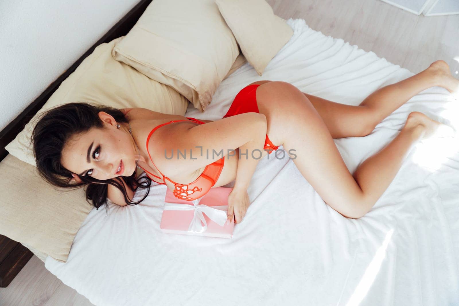 a woman in red underwear in the morning in bed in the bedroom