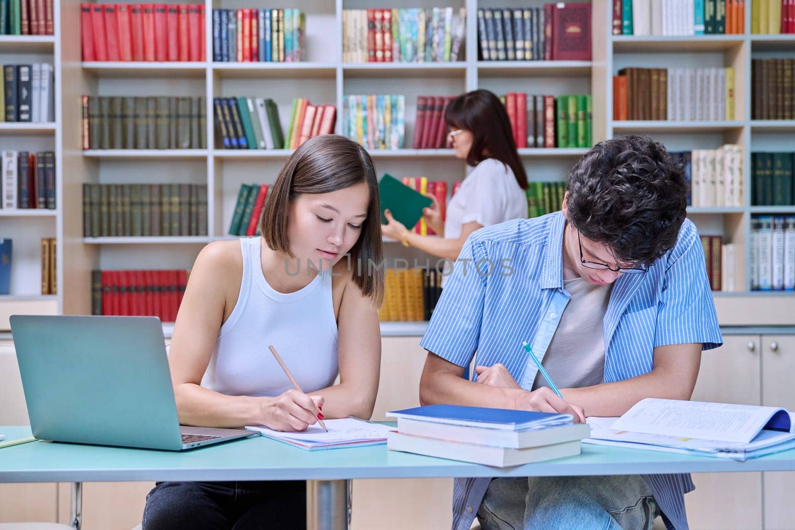 College students guy and girl study in library by VH-studio