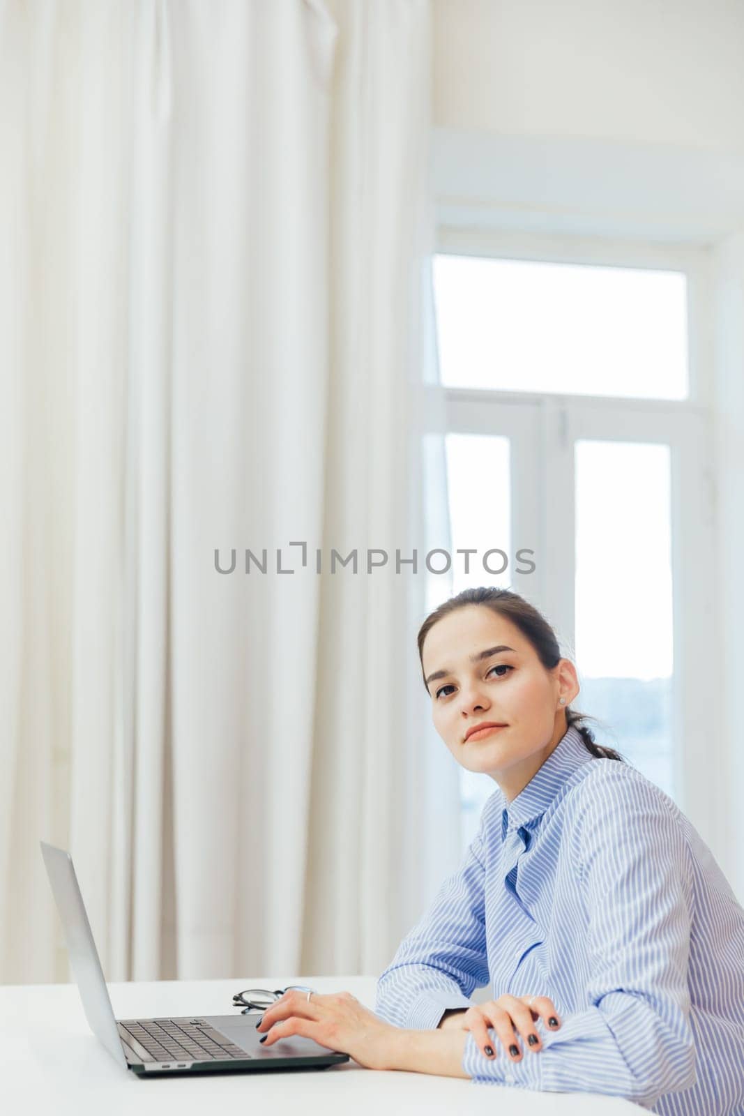 a woman with laptop in office at remote work internet communication IT work