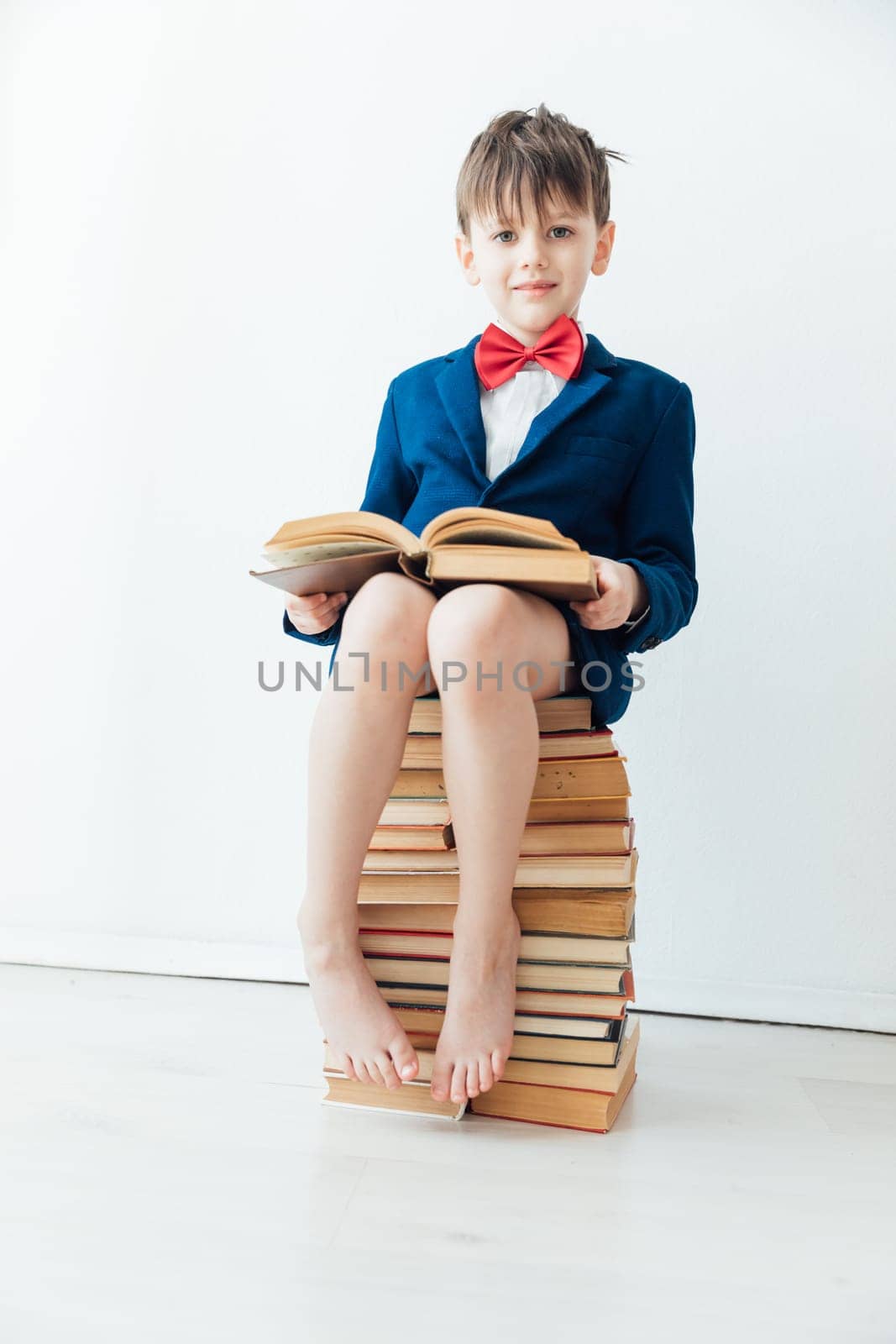 an important boy sitting on books teaching school class