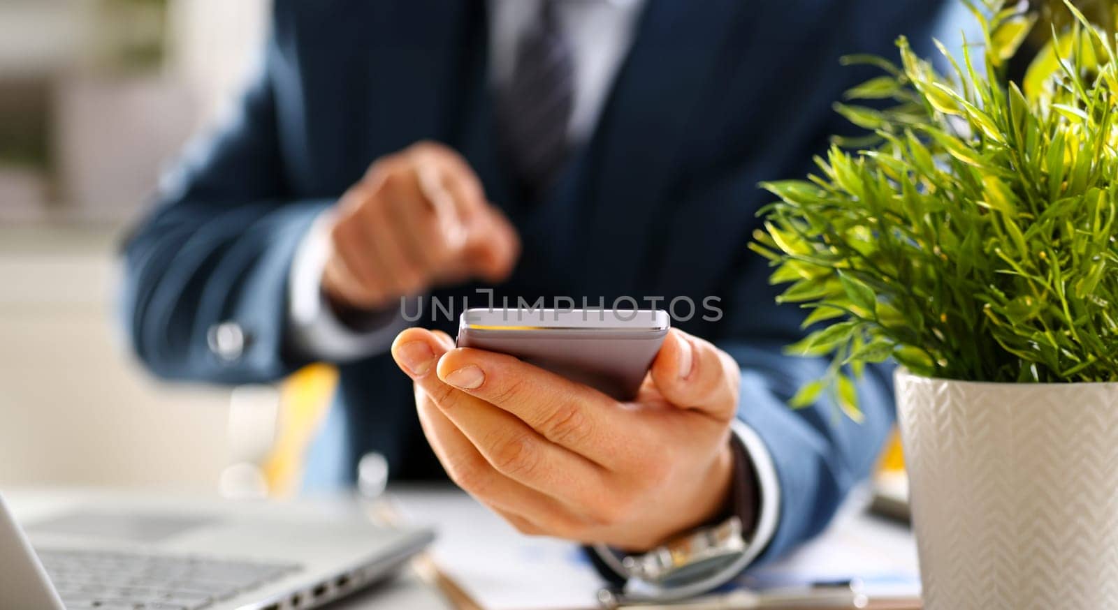 Male arm in suit hold phone and silver pen at workplace closeup. Read news mania send sms chat addict use electronic bank modern lifestyle job plan colleague share blog tweet web application search