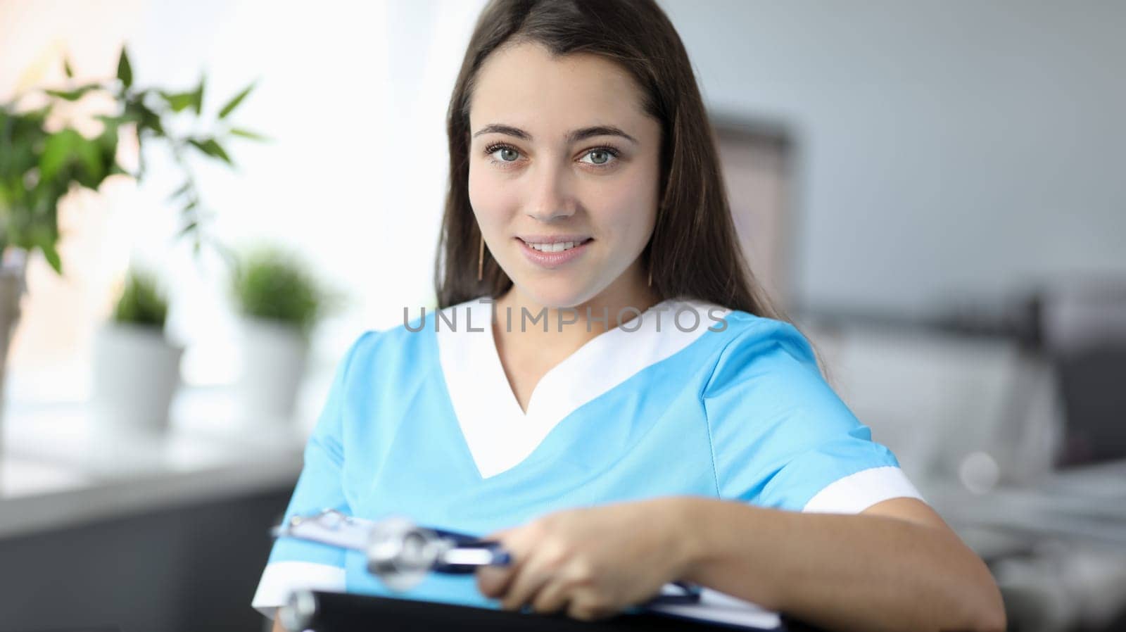 Portrait of smiling beautiful woman with medical equipments. Wonderful doctor looking at camera with happiness and calmness. Medicine and healthcare concept