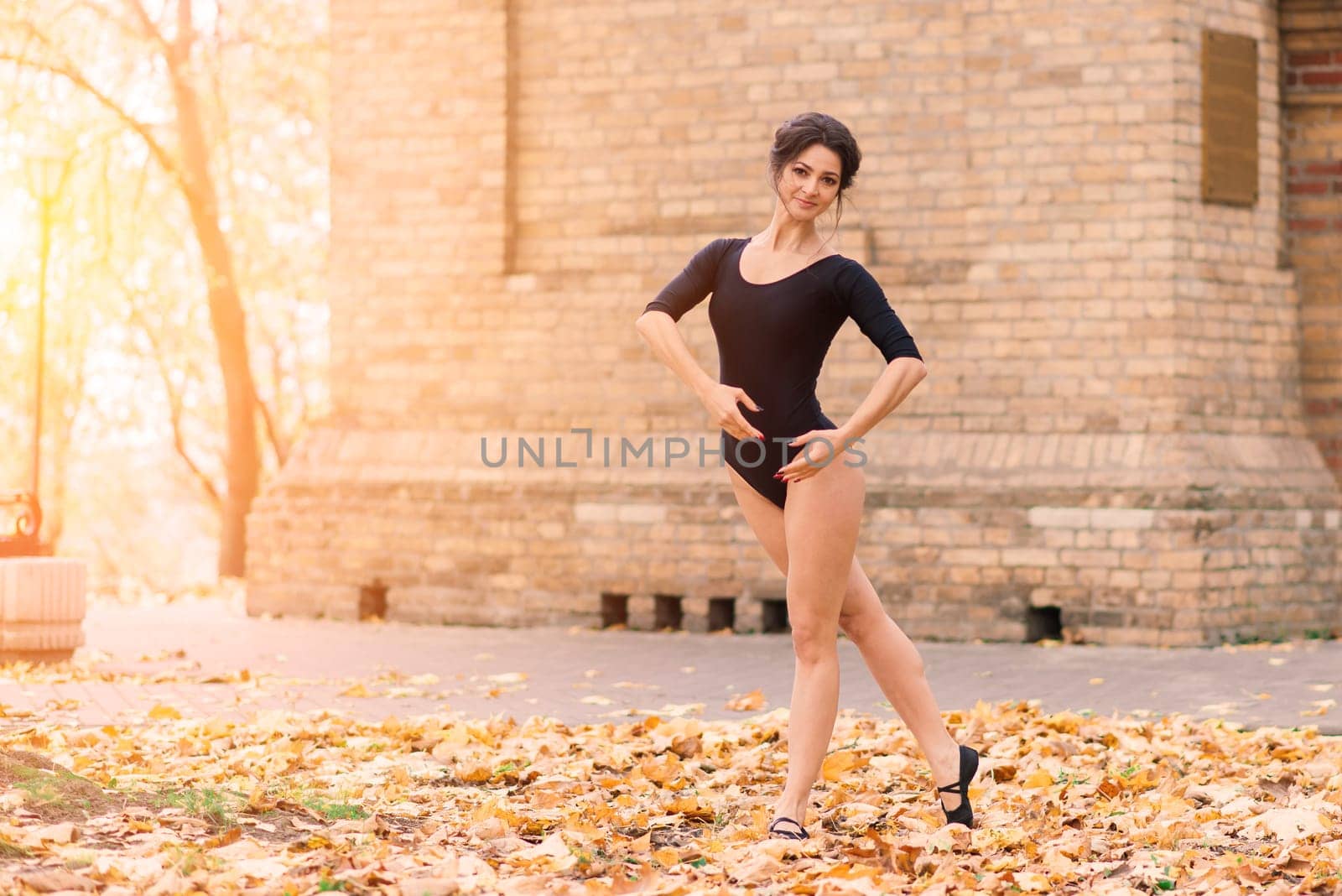 Beautiful female, ballerina, athlete in black bodysuit training in the park by Zelenin
