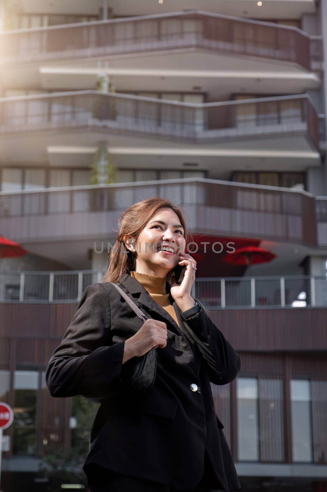 Asian businesswoman smiling happily while talking on mobile phone Business woman calling on smartphone outside the office business contacts.