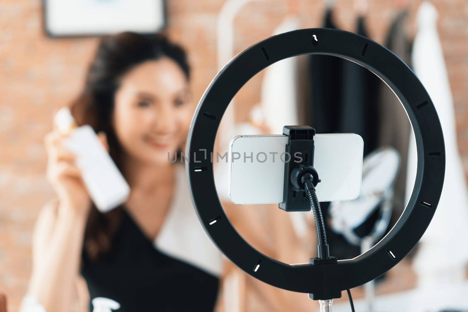 Asian Woman influencer shoot live streaming vlog video review makeup uttermost social media or blog. Happy young girl with cosmetics studio lighting for marketing recording session broadcasting online