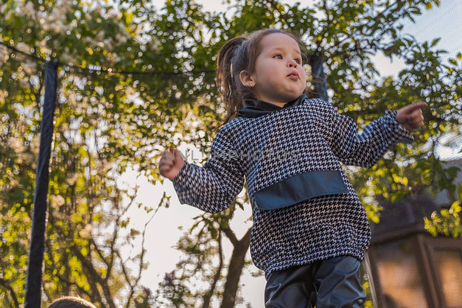 girl jumping on a trampoline which is outdoors