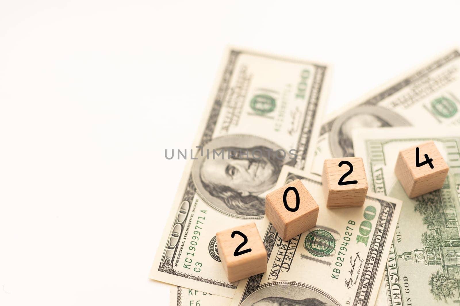 2024 inscription on wooden cubes on the texture of us dollars and euro banknotes by Andelov13