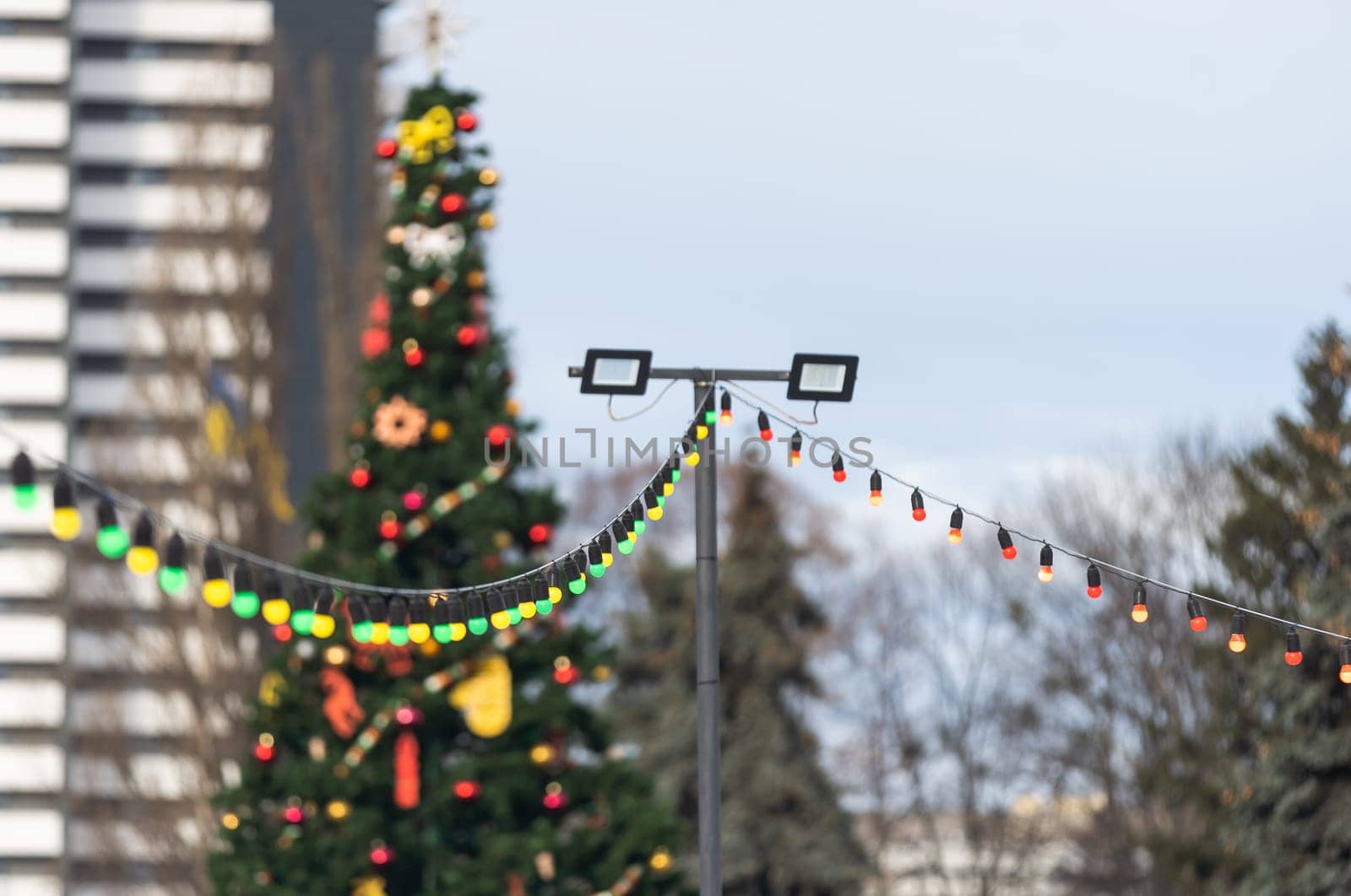 Christmas market in a European city. Wooden houses are illuminated by garlands and Christmas decorations in the evening. Christmas decorations at the fair