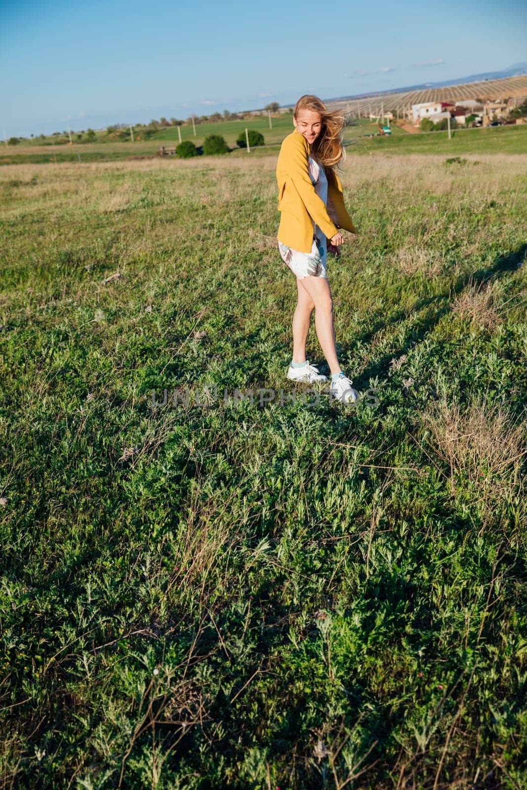 a walk a blonde woman walking in nature on the green grass in the field journey