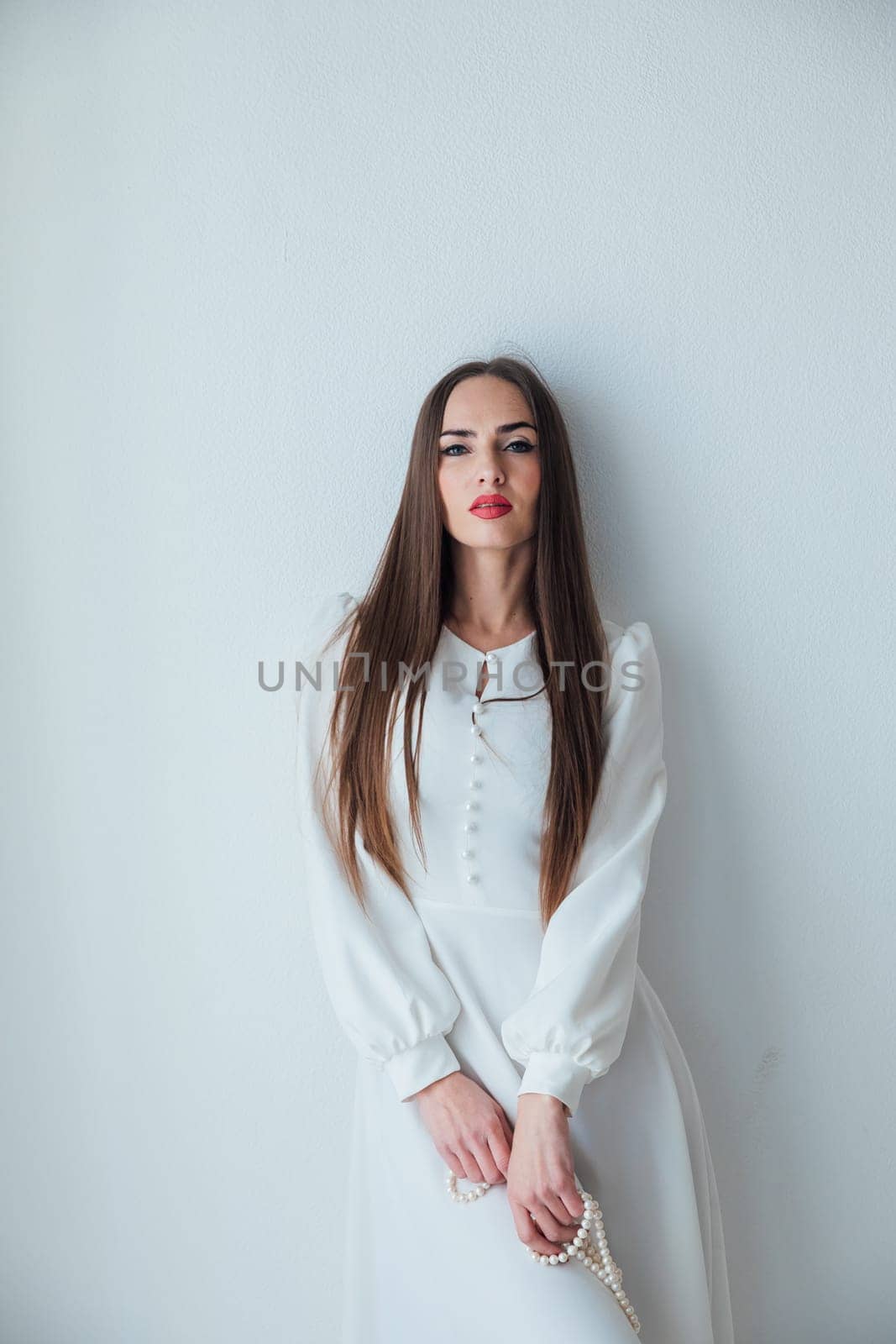 a beautiful woman with beaded beads posing on a white fashion background