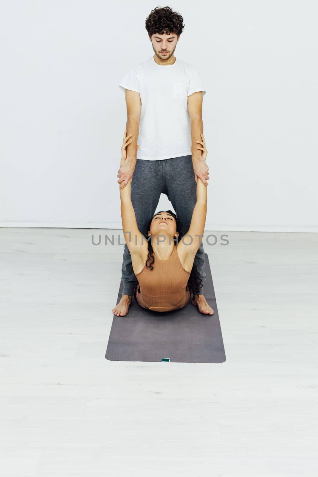 acrobatics yoga poses woman and man do gymnastics warm-up exercises asana flexible body by Simakov