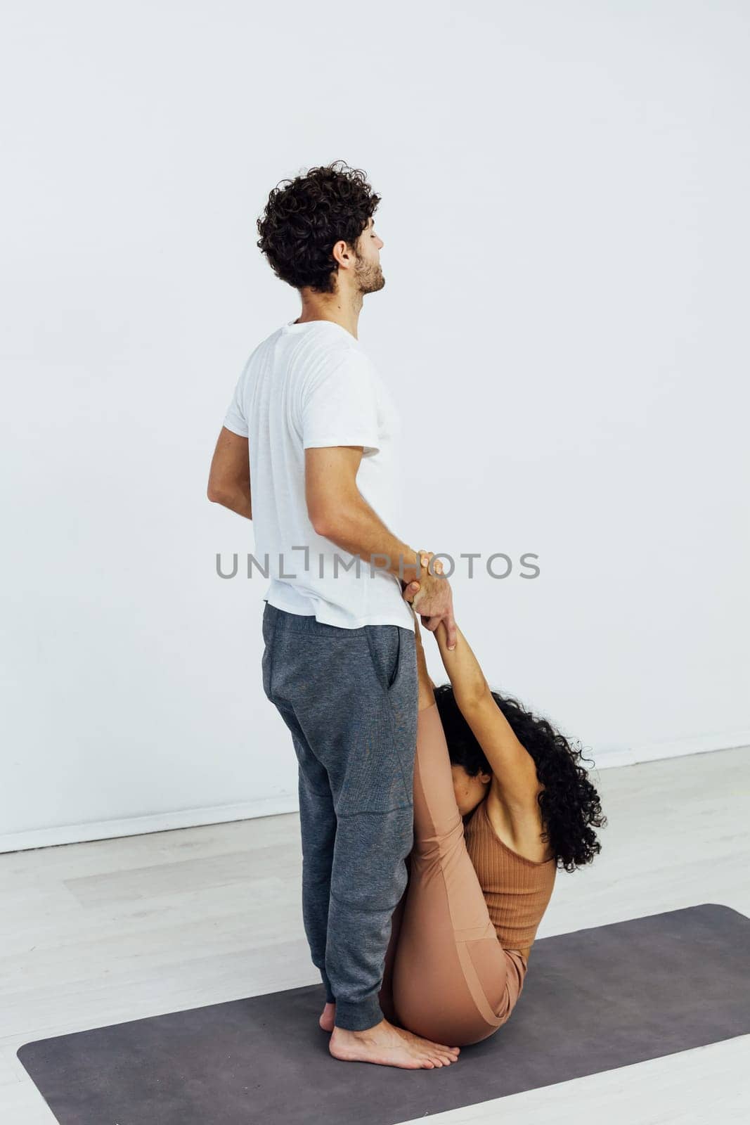 man and woman do gymnastics warm-up yoga asana posture exercises by Simakov
