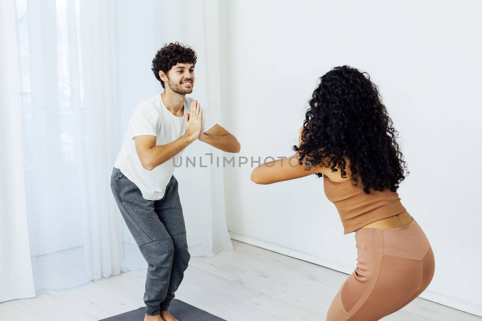 a woman and a man do gymnastics warm-up exercises yoga asana poses by Simakov