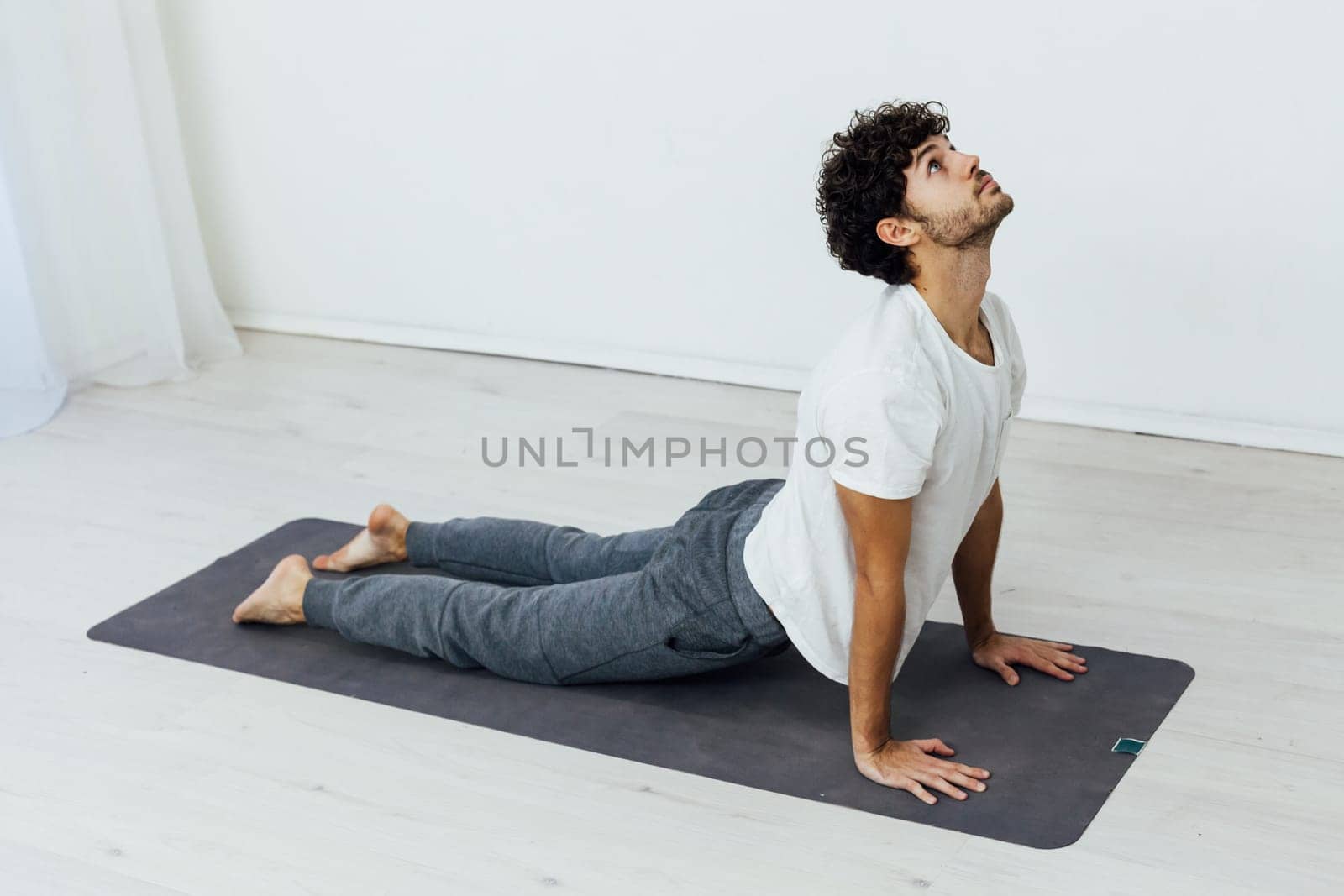 a man does gymnastics warm-up exercises yoga by Simakov