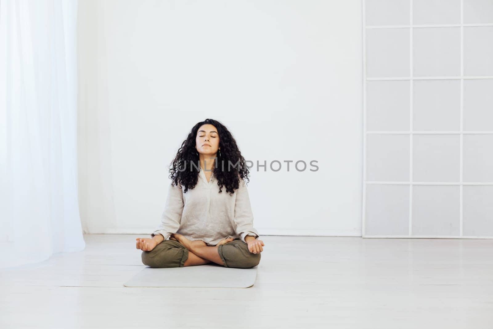 woman doing yoga lotus pose relaxation exercises by Simakov
