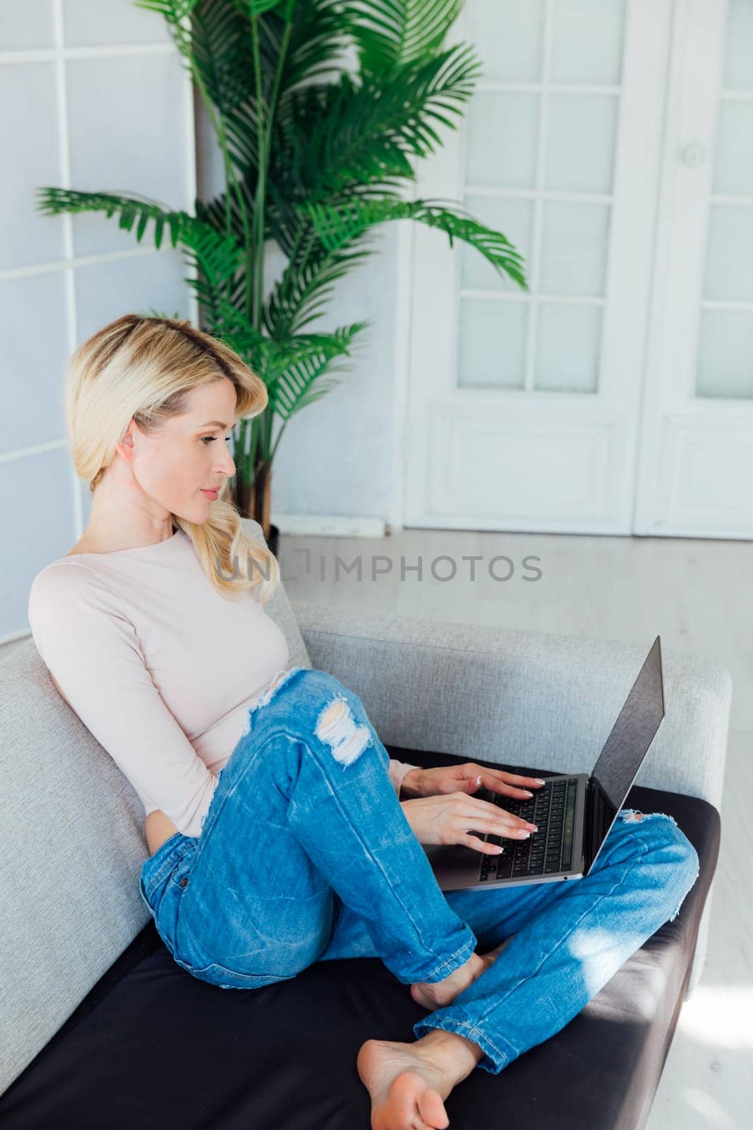 woman with a laptop in the room works remotely online internet communication