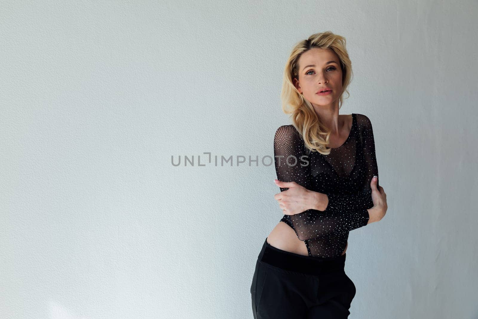 beautiful blonde in black fashionable clothes on a white background by Simakov