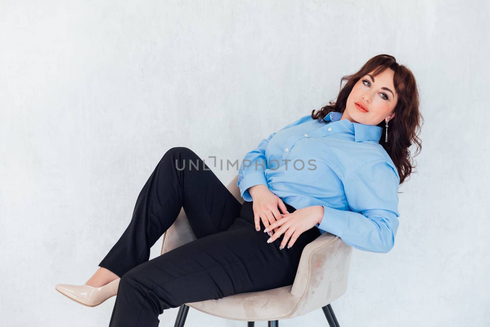 business woman sits in a chair on a white background