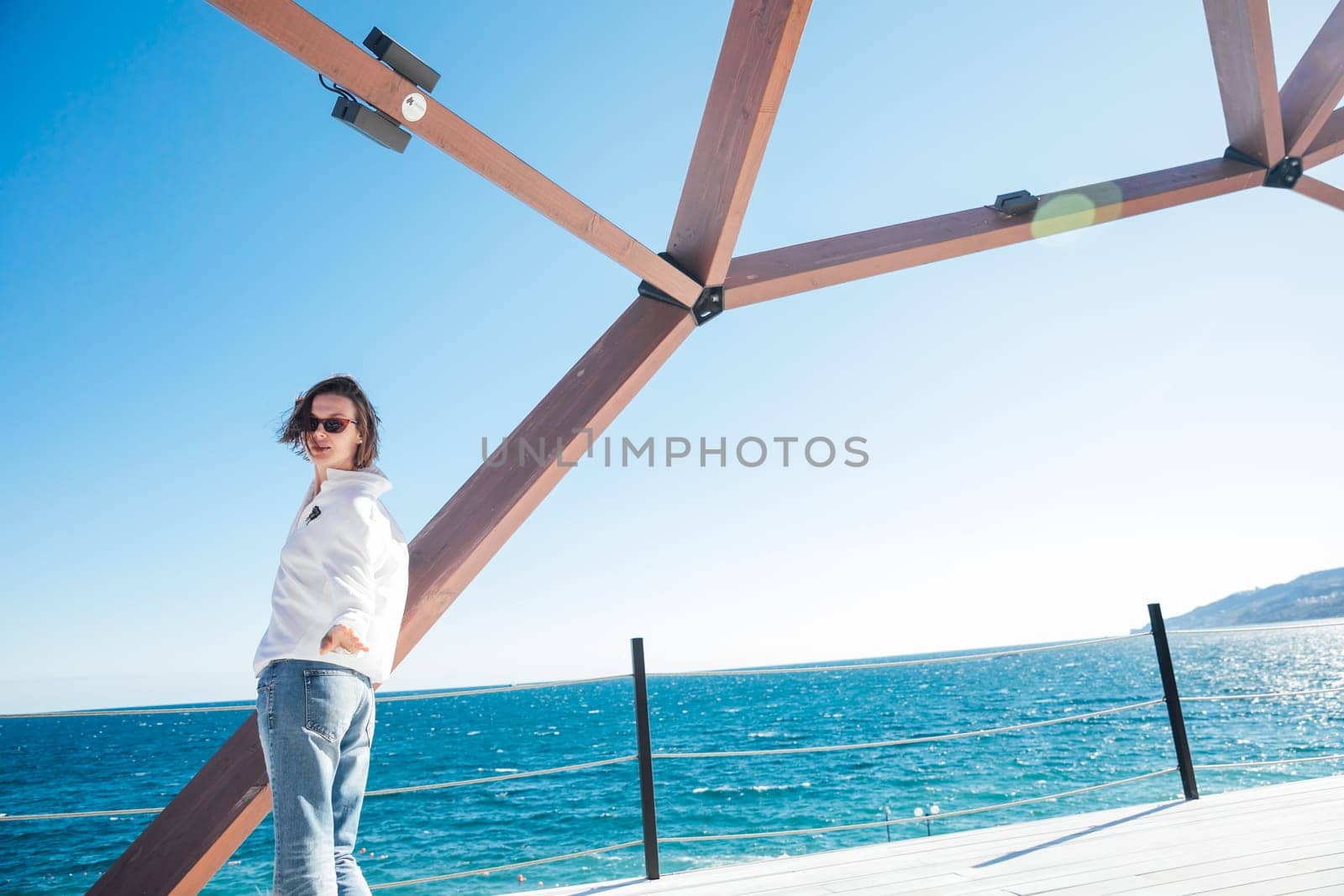 beautiful woman under a wooden structure near the sea