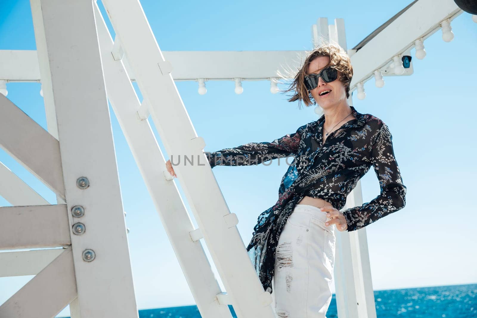 woman by the sea near a wooden structure