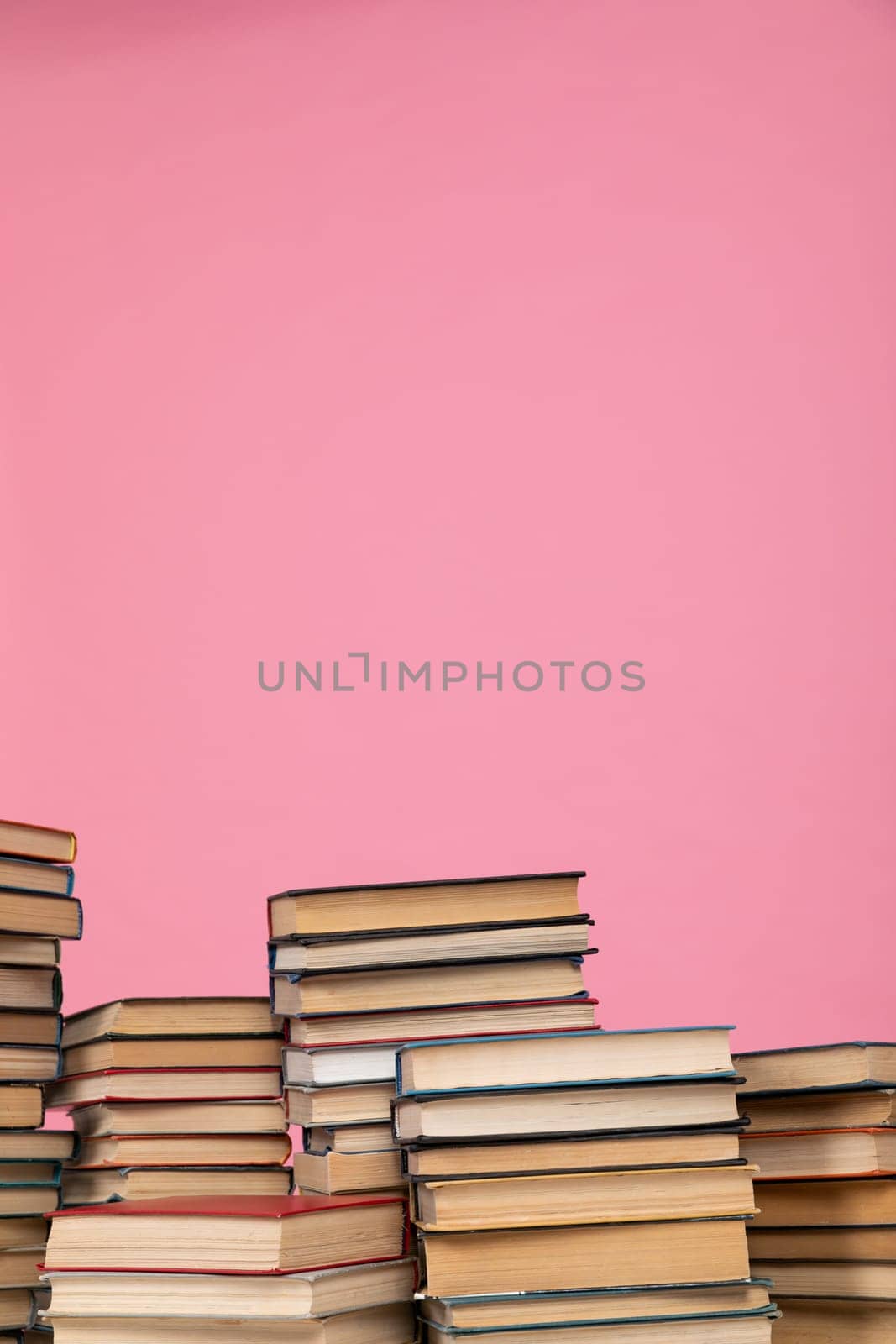 education science stack of books in the library on pink background