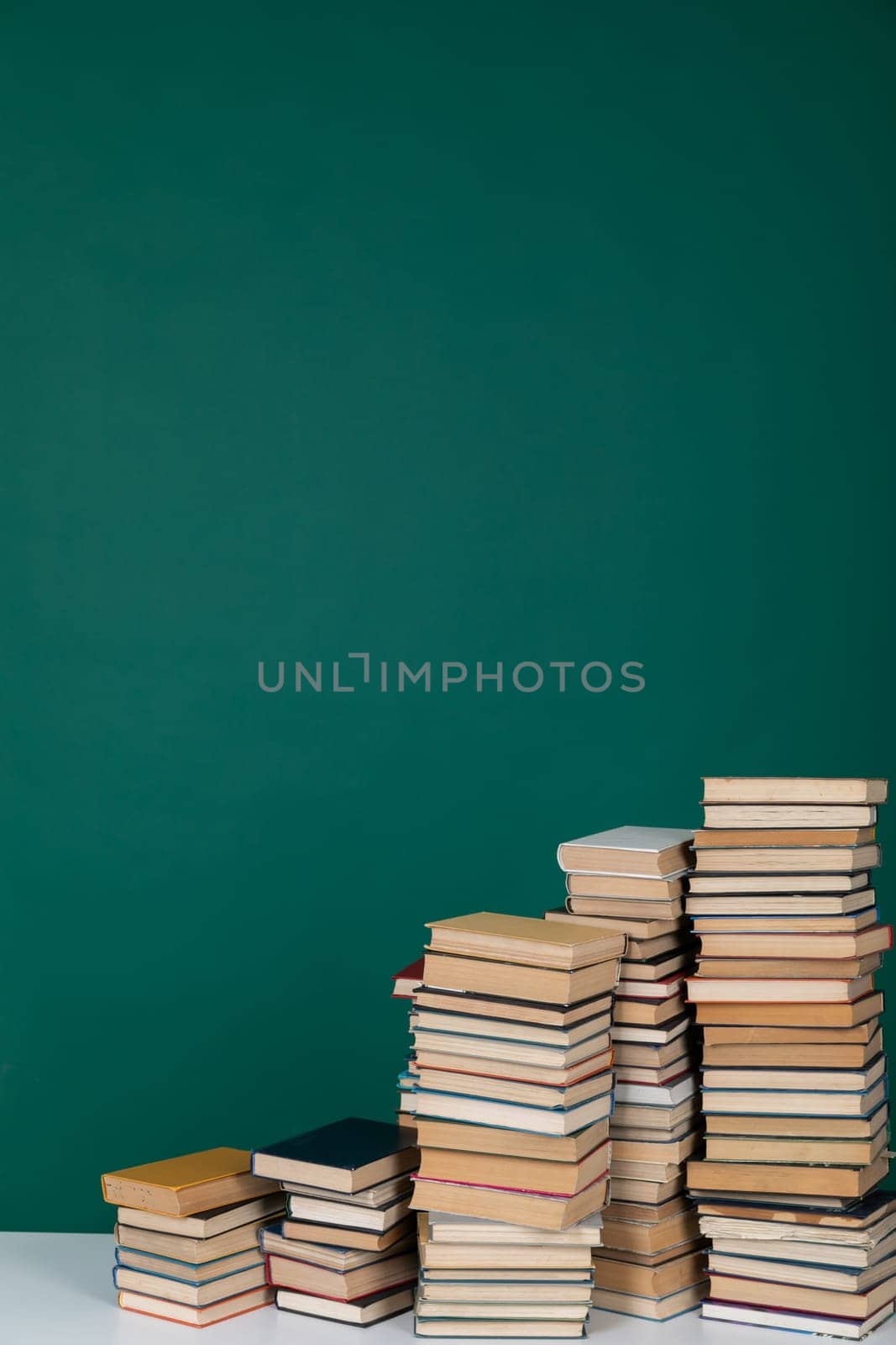 stack of books in the library on a green background training education science by Simakov