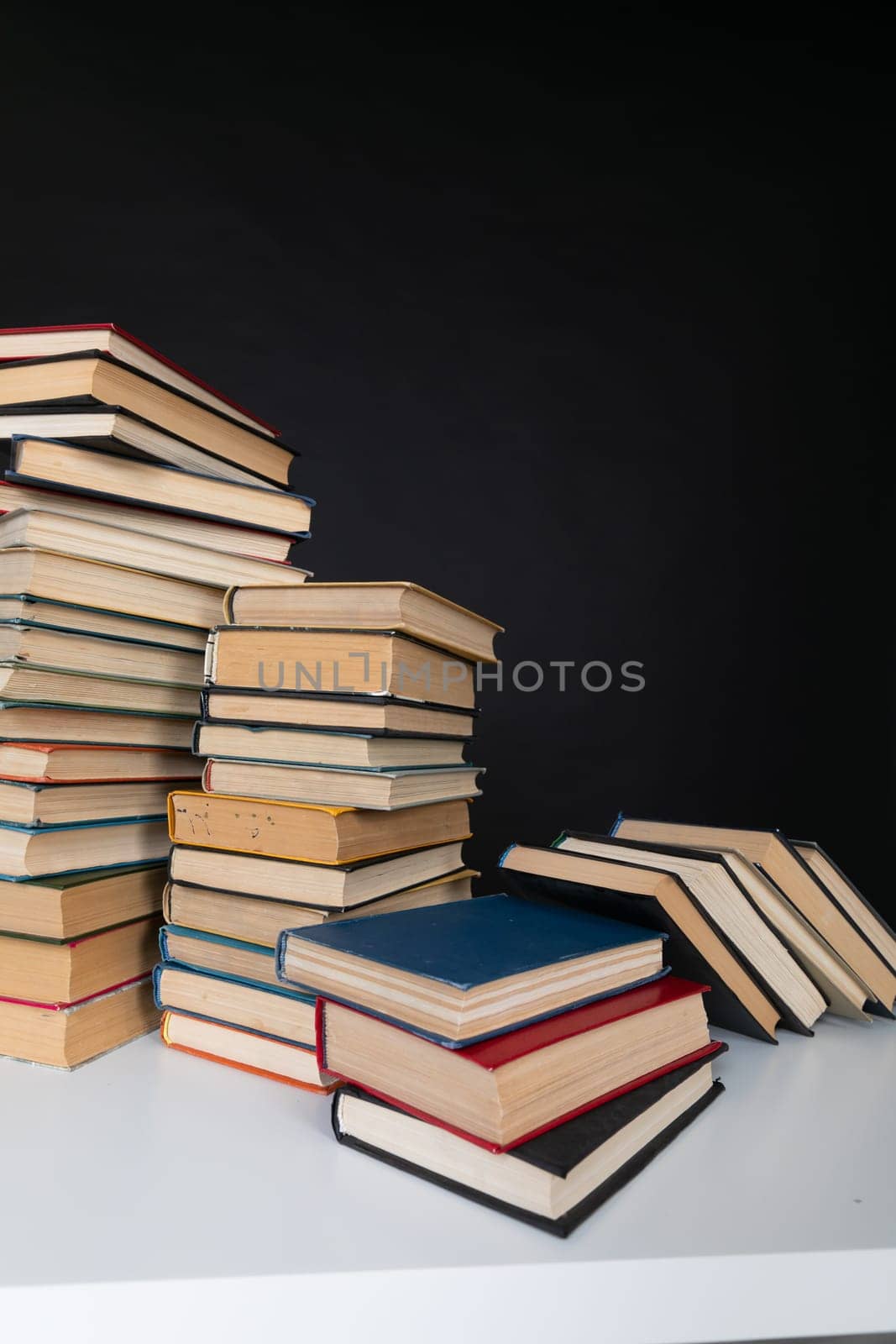 a stack of books in the library on a black background training education science by Simakov