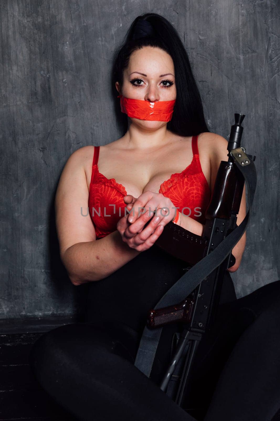 brunette woman in a dark room with a machine gun by Simakov